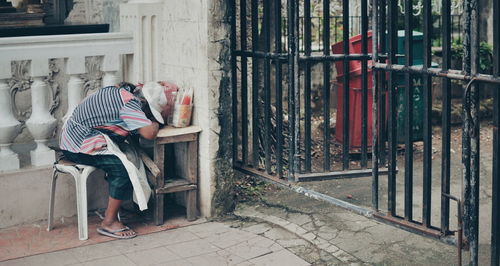 Side view of a woman sitting on the wall