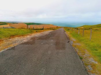 Empty road along countryside landscape