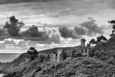 Old building by sea against sky