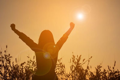 Silhouette woman against sky during sunset