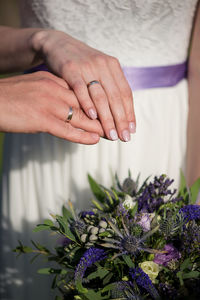 Bride and bridegroom with wedding rings over bouquet