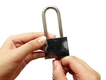 Close-up of person holding metal against white background