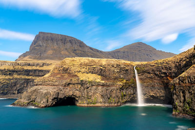 Scenic view of waterfall against sky