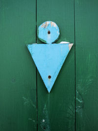 Close-up of blue shapes on green wooden door