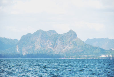 Scenic view of sea and mountains against sky