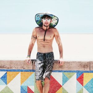 Full length of shirtless man standing at beach