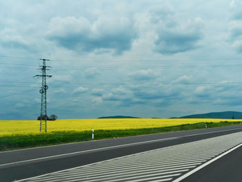 Electricity pylon on field against sky
