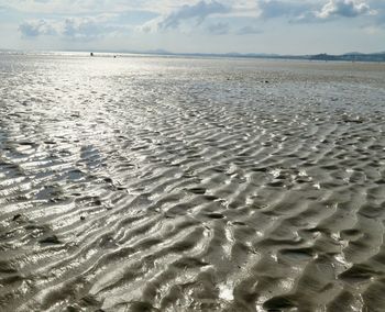 Surface level of sandy beach against sky