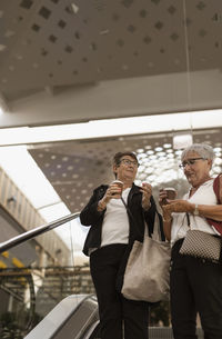 Smiling women on escalator