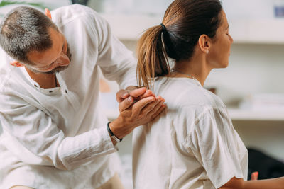 Woman enjoying shiatsu back massage, sitting on the shiatsu massage mat.