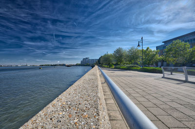 Scenic view of river against sky in city