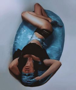 High angle view of young woman relaxing in bathtub