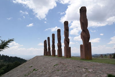 Wooden posts on field against sky