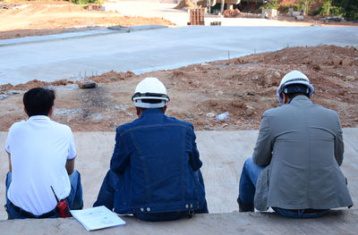 Rear view of engineers sitting in city