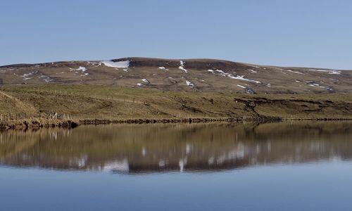 Scenic view of lake against clear blue sky