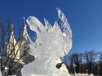 Low angle view of snow against clear blue sky
