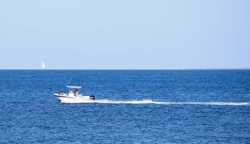 Sailboat sailing in sea against clear sky