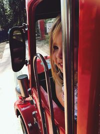 Close-up of girl in red car