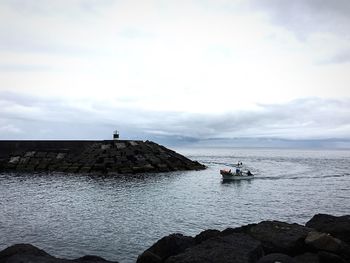 Boat sailing on sea against sky