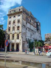 People on street against buildings in city