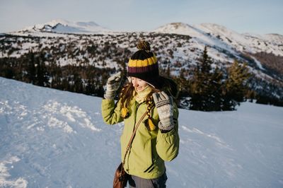 Woman with umbrella on snowcapped mountains during winter