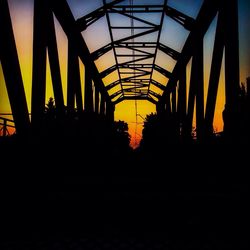 Low angle view of bridge against sky at sunset