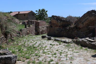 View of old house and trees against sky