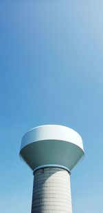 Low angle view of water tower against clear blue sky