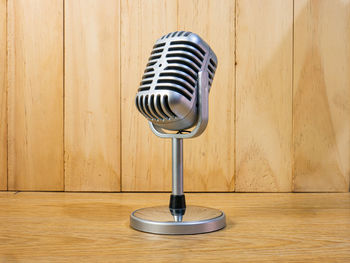 Close-up of electric lamp on table against wall