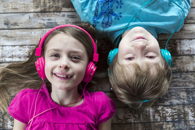 Portrait of brother and little sister hearing music with headphones