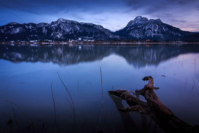 Scenic view of lake by mountains against sky