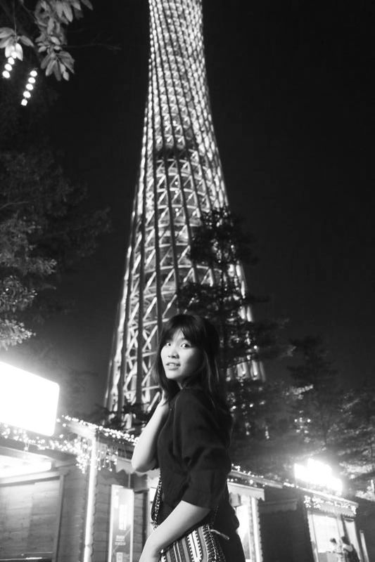 LOW ANGLE VIEW OF YOUNG WOMAN STANDING IN ILLUMINATED BUILDING