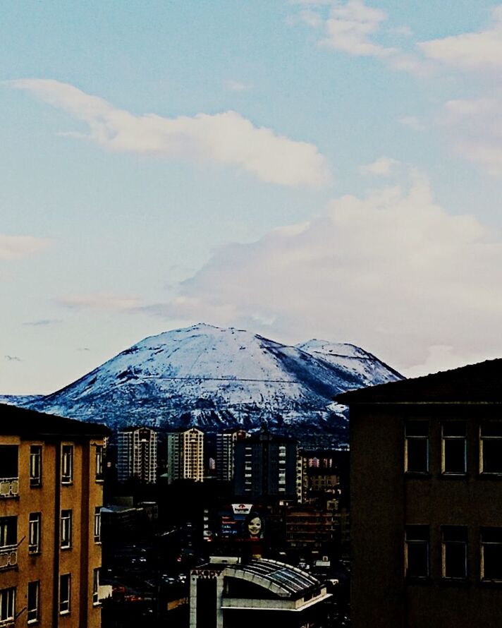 architecture, building exterior, built structure, snow, mountain, winter, sky, cold temperature, cloud - sky, residential building, residential structure, city, house, weather, mountain range, roof, snowcapped mountain, low angle view, outdoors, day