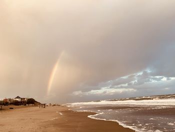 Scenic view of rainbow over sea against sky