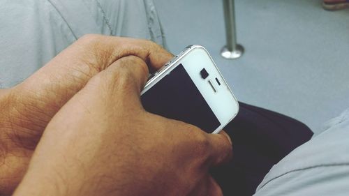 Midsection of man holding mobile phone