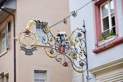 Low angle view of a sign hanging on wall of building