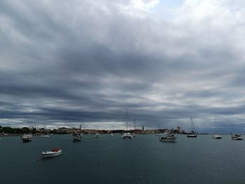 Sailboats in sea against sky