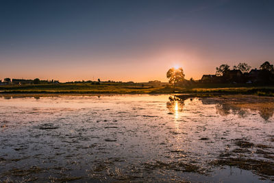 Scenic view of land against sky during sunset