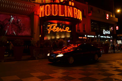 Cars on illuminated street in city at night