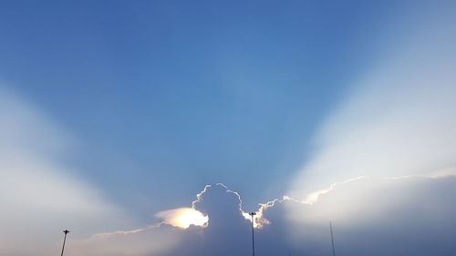 Low angle view of illuminated blue sky on sunny day