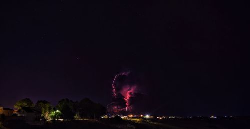 Low angle view of illuminated fireworks against sky at night