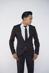 Young man standing against white background