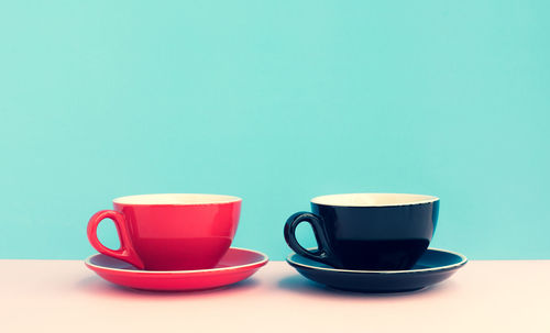 Coffee cup on table against blue background