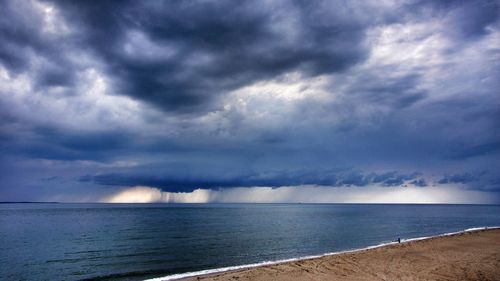 Scenic view of beach and sea against cloudy sky