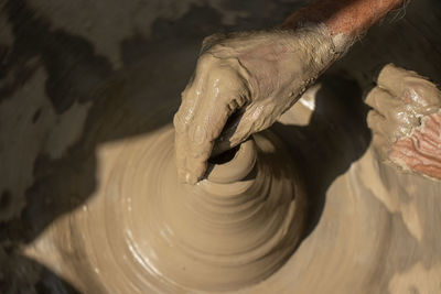 Cropped image of man working on pottery wheel