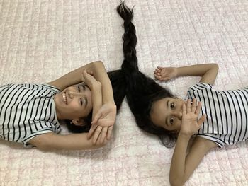 High angle portrait of girls relaxing on bed at home