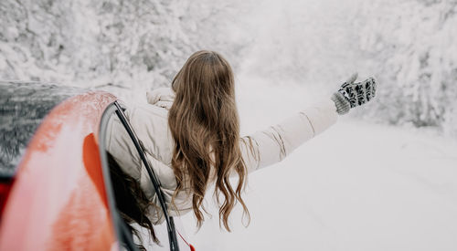 Rear view of people on snow covered landscape during winter