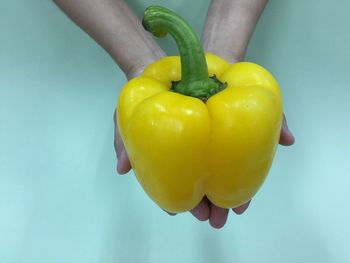 Close-up of hand holding yellow bell peppers