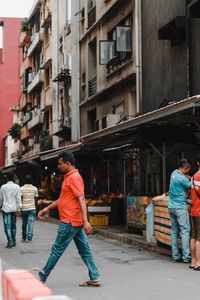 People walking on street against buildings in city