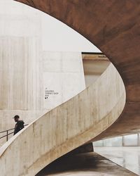 Man moving down on spiral staircase against wall